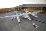 Virgin Galactic's first SpaceShipTwo suborbital spaceliner (center) is seen mated to its WhiteKnightTwo mothership in front of the 