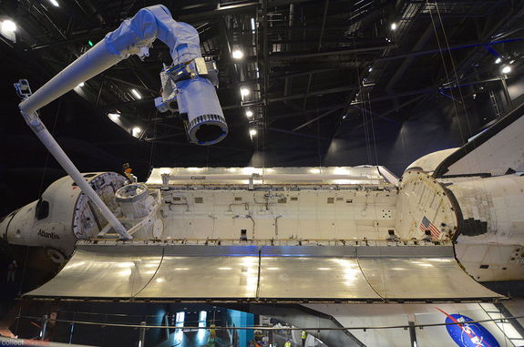 With its payload bay open, Canadarm robotic arm deployed and window covers removed, space shuttle Atlantis is ready for its public debut on June 29, 2013 at NASA's Kennedy Space Center Visitor Complex in Florida. 