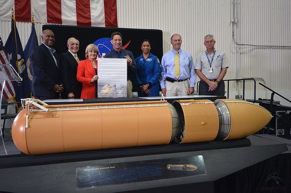 NASA and California Science Center officials present a signed title transfer document for the last space shuttle external tank, ET-94, during a ceremony at the Michoud Assembly Facility on Tuesday, April 12, 2016. Pictured from left to right: Bobby Watkins, Michoud Assembly Facility director; Parker Counts, NASA’s project manager for the external tank from 1992-1999; Jody Singer, Marshall Space Flight Center deputy director; Jeffrey Rudolph, California Science Center president; Jeanette Epps, NASA astronaut; Steve Cash, former space shuttle propulsion office manager; and Dennis Jenkins, project director for Endeavour's display at the California Science Center. 