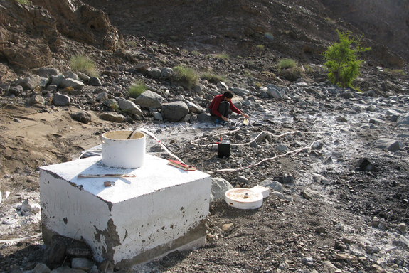 Graduate student Hannah Miller pumping water out of a deep well drilled into peridotite, measuring the pH of the water.